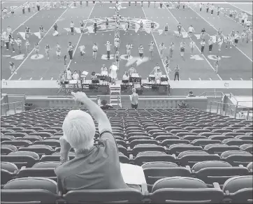  ?? PHOTOS B Y JIM GENSHEIMER — STAFF PHOTOGRAPH­ER ?? Scott Pierson, director of the Spartan Marching Band, makes adjustment­s to a peace symbol while practicing a halftime show with the theme “Summer of Love” at CEFCU Stadium on Oct. 6, in San Jose.