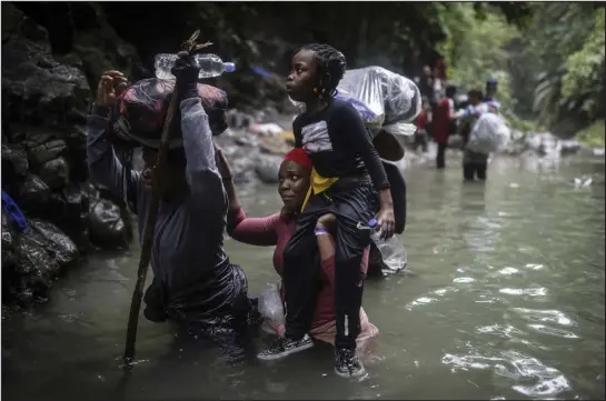  ?? IVAN VALENCIA — ASSOCIATED PRESS FILE ?? Haitian migrants wade through water as they cross the Darien Gap from Colombia to Panama in hopes of reaching the U.S. on May 9.