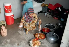  ??  ?? A displaced woman from Mosul prepares a Ramadan meal for her family at a refugee camp on the outskirts of Erbil in Iraq.