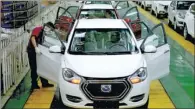  ?? XU CONGJUN / FOR CHINA DAILY ?? A worker checks new energy cars on a production line of JAC Motors in Anhui province.