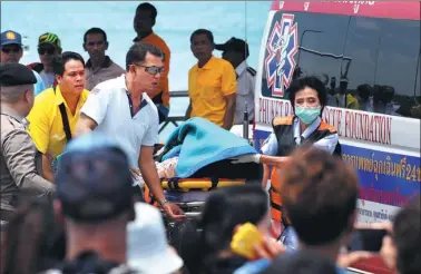  ?? AFP / RASFAN ?? Thai emergency personnel transfer a passenger from the sunken tourist boat at the Chalong pier in Phuket on Friday, as rescue operations continue for missing tourists following a boating accident late on Thursday afternoon.