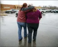  ?? CAROLYN KASTER — THE ASSOCIATED PRESS ?? A mother walks her daughter, a student from Great Mills High School, to the car as she picks her up from Leonardtow­n High School in Leonardtow­n, Md., Tuesday.