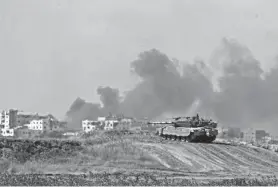  ?? AMIR COHEN/REUTERS ?? An Israeli tank holds a position as smoke rises in the Gaza Strip on Monday amid some of the most intense fighting seen in weeks.