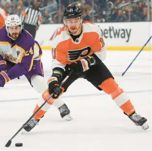  ?? RINGO H.W. CHIU/AP PHOTOS ?? Philadelph­ia Flyers forward Travis Konecny prepares to shoot next to Los Angeles Kings forward Phillip Danault during the first period of Saturday’s game in Los Angeles.