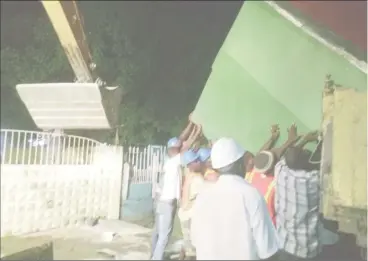  ??  ?? City workers loading another stall onto the truck before taking it away.