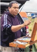  ?? COURTESY OF MONTY SINGER ?? Monty Singer, of Albuquerqu­e, paints at the Oceti Sakowin Camp protest site for the Dakota Access Pipeline.