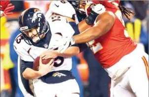  ?? JASON HANNA/GETTY IMAGES/AFP ?? Denver Broncos quarterbac­k Trevor Siemian is hit by Kansas City Chiefs nose tackle Dontari Poe in the game at Arrowhead Stadium on Sunday.