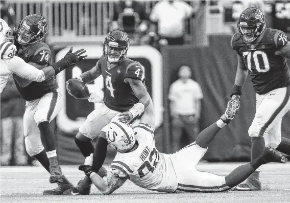  ?? Godofredo A. Vasquez / Staff photograph­er ?? Texans quarterbac­k Deshaun Watson (4) is brought down by the Colts’ Margus Hunt during the fourth quarter for one of five sacks he absorbed in Sunday’s setback.