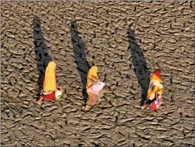  ?? REUTERS ?? Women walk on the muddy banks of the Ganges river after taking a holy dip, in Allahabad on Tuesday.