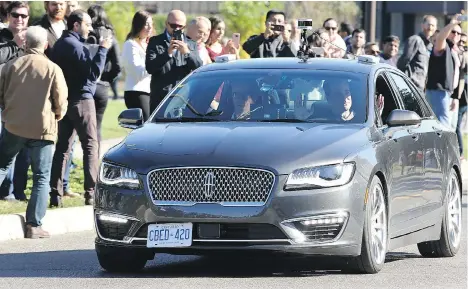  ?? JULIE OLIVER ?? David van Geyn, right, from Blackberry QNX, holds up his hands to demonstrat­e the driverless car test, with Ottawa Mayor Jim Watson, left, and others joining the ride Thursday in suburban Ottawa. It was touted as the first street test of an autonomous...