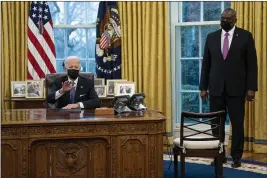  ?? EVAN VUCCI — THE ASSOCIATED PRESS ?? Secretary of Defense Lloyd Austin listens as President Joe Biden speaks before signing an executive order in the Oval Office on Monday.