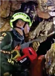  ??  ?? Drill: Rescuer tries to widen cave shaft