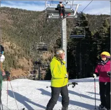  ?? GEOFFREY PLANT/Taos News ?? Bethany Griffith, volunteer snow ranger for the Carson National Forest, talks snow making with one of the interpreti­ve tour’s participan­ts last Saturday, as one alpine skier rides Sipapu Ski and Summer Resort Lift 1 above, outfitted with gear that reflected the springlike conditions at the resort last weekend.