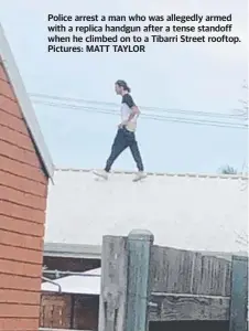  ??  ?? Police arrest a man who was allegedly armed with a replica handgun after a tense standoff when he climbed on to a Tibarri Street rooftop. Pictures: MATT TAYLOR
