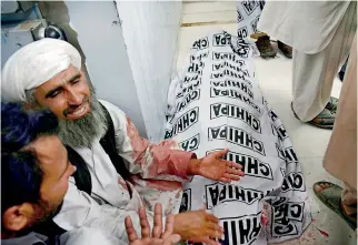  ??  ?? Pakistani men mourn the death of a relative after a bomb blast at an election rally, at a hospital in Quetta on July 13, 2018. A bomb killed at least 25 people and injured more than 30 on July 13 in southweste­rn Pakistan, in the day's second attack on...