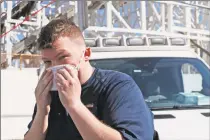  ?? Kathy Willens / Associated Press ?? Evan Demaree, a Heartland Disaster Response Team ambulance attendant from Lafayette, Ind., dons his face mask before taking a stroll on the boardwalk at Coney Island in New York on Thursday.