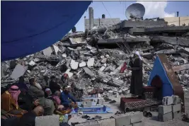  ?? FATIMA SHBAIR — THE ASSOCIATED PRESS ?? Palestinia­ns pray in front of a mosque destroyed by the Israeli airstrikes in Rafah, Gaza Strip on Friday ahead of the holy Islamic month of Ramadan.