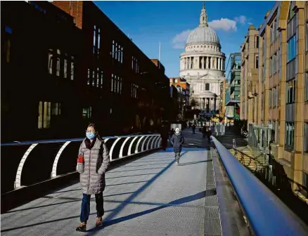  ?? Tolga Akmen/AFP ?? Pessoas caminham na ponte Millennium, em Londres, durante lockdown por causa da piora da pandemia