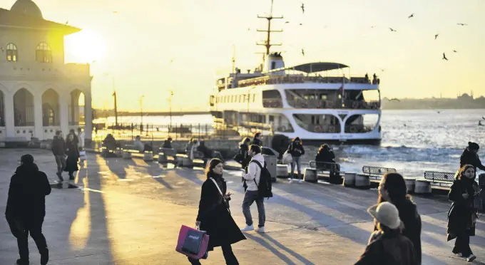  ?? ?? People walk along a promenade next to the Bosporus at the Kadiköy ferry terminal in Istanbul, Türkiye, March 22, 2024. (AP Photo)