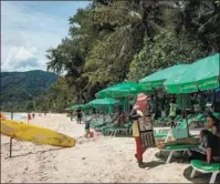  ?? JACK TAYLOR / AGENCE FRANCE-PRESSE ?? A beach vendor offers drinks to tourists in Phuket on Aug 14. Vaccinated foreign travelers have been allowed to skip quarantine­s on the resort island.