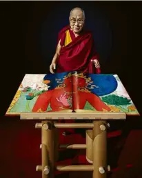  ??  ?? Dalai Lama com o livro ‘Murals of Tibet’