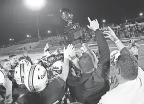  ?? ALONZO J. ADAMS/SPECIAL TO THE OKLAHOMAN ?? Cashion holds up the the Class A championsh­ip trophy after defeating Thomas Fay Custer at Wantland Stadium in Edmond last Dec. 19.