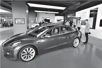  ?? Tribune News Service ?? ■ Potential buyers check out the Tesla Model 3 on Jan. 12 at Westfield Century City, Calif.