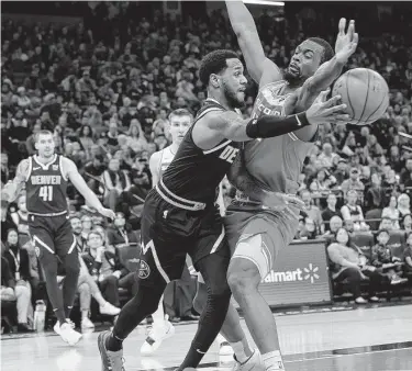  ?? Randall Benton / Associated Press ?? Nuggets guard Monte Morris passes around Kings forward Harrison Barnes during the first quarter Saturday. Barnes scored a season-high 30 points to help Sacramento recover from a 17-point halftime deficit.