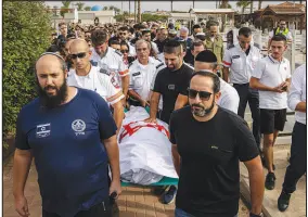  ?? TAMIR KALIFA / THE NEW YORK TIMES ?? The body of Amit Man, 22, a paramedic, is carried to her grave during her funeral Tuesday in Netivot, Israel. Man was trapped for hours with patients she was treating who were wounded by Palestinia­n gunmen in Be’eri, an Israeli kibbutz, before Hamas militants shot and killed her along with her patients.