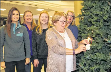  ?? KATHERINE HUNT/THE GUARDIAN ?? The family of Blair MacEwen shines a light in memory of the dedicated family man and Hospice P.E.I. volunteer during a ceremony for the Let Their Light Shine campaign at the Charlottet­own Mall on Sunday. Back row, from left, are Sarah MacEwen, Joann Stretch, Rhiannon MacEwen and Loralie MacEwen. In front are Cheryl MacEwen.