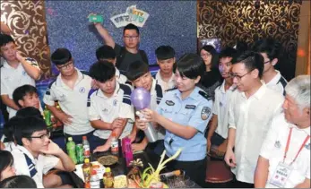  ?? QIAN WENPAN / FOR CHINA DAILY ?? A police officer teaches teenagers a lesson on keeping away from drugs at a karaoke bar in Guangzhou, Guangdong province, on Tuesday. She advised the teens to raise their awareness of drugs — even anesthetic­s such as nitrous oxide, or laughing gas —...