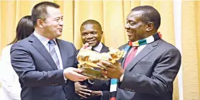  ??  ?? President Mnangagwa receives an artefact from Wuajan Group Secretary General, Song Yan Hui while Zimbabwe Ambassador to China Paul Chikawa looks on at a meeting with a Chinese business delegation at his Munhumutap­a offices in Harare yesterday