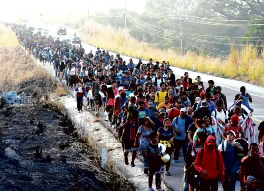  ?? EDGAR H. CLEMENTE/ASSOCIATED PRESS ?? Migrants, headed to the US border, walked along a highway in southern Mexico, Monday. The Senate is trying to reach agreement on a bipartisan border security proposal to garner Republican support for Ukraine aid.