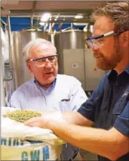  ?? SUBMITTED PHOTO — VICTORY BREWING CO. ?? Sen. John Rafferty, R-44 of Collegevil­le, and Bill Covaleski, co-founder and brewmaster of Victory Brewing Co. in Downingtow­n, inspect whole flower hops in the Parkesburg brewery.