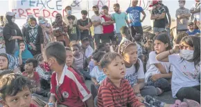  ??  ?? Asylum seekers displaced from the Moria camp, including many children, during a protest against relocating to a temporary tented camp.