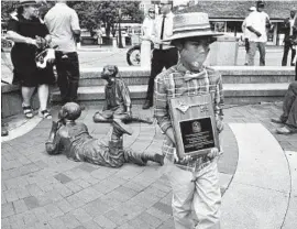  ??  ?? Alex Haley’s great-grandnephe­w Tyler Stallings, 10, carries a key to the city that his family was given Saturday near the Kunta Kinte-Alex Haley Memorial at City Dock in Annapolis.