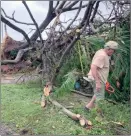  ?? The Associated Press ?? Andy Villagomez clears what remains of a large tree that overshadow­ed his front yard before falling to Typhoon Mawar, Thursday, in Guam.