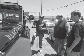  ?? Gazette file photo ?? ■ Mark White talks with Wes and Jacob Pryor about his modified Jeep Wrangler at the 11th annual Four States Auto Museum Car Show on May 7, 2016. White outfitted his car with off-road and survival gear that he can live off of for a month. The chains...