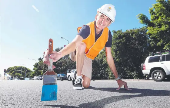  ?? Picture: RICHARD GOSLING ?? Marathon champion Michael Shelley begins the painting of the blue marathon line that will go around the city.