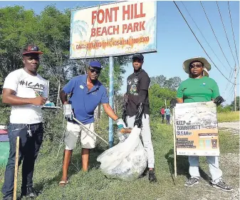  ??  ?? Sandals Foundation volunteers send a message of ‘keeping communitie­s and coastlines clean’ while they themselves clean up sections of the Font Hill coastline for Internatio­nal Coastal Clean-up day last Saturday. Together, the group removed over 230lbs of debris from the area in just under an hour and encouraged passing commuters to keep the area trash free.