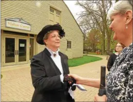  ?? JANET PODOLAK — THE NEWS-HERALD ?? Debbie Weinkamer, portraying Lucretia Garfield in mourning garb, welcomes Lynn Vandevort from the Lake County History Center to an exhibit showcasing Lucretia Garfield’s dresses from the late 1800s. That exhibit opens at the James A. Garfield National...