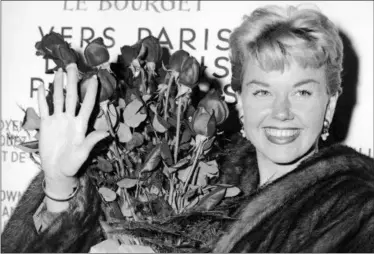  ?? THE ASSOCIATED PRESS ?? American actress and singer Doris Day holds a bouquet of roses at Le Bourget Airport in Paris after flying in from London. The Doris Day Animal Foundation confirmed Day died early Monday at her home in Carmel Valley She was 97.