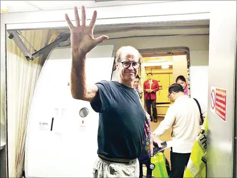  ?? IMMIGRATIO­N POLICE ?? Australian filmmaker James Ricketson boards a plane at Phnom Penh airport on Sunday .