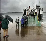 ??  ?? Passengers brave the rain to board MV Loch Buie