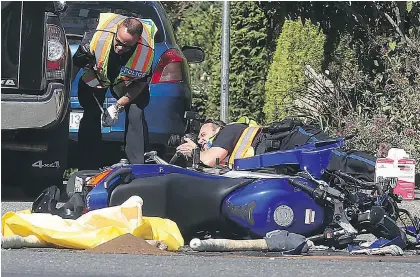  ?? ADRIAN LAM, TIMES COLONIST ?? Saanich Police and first responders investigat­e the scene of a motor vehicle collision involving a truck and a motorcycle at the intersecti­on of Boleskine and Whittier roads. The motorcycli­st died at the scene.