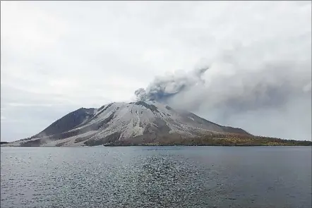  ?? AP photo ?? Mount Ruang volcano is seen during the eruption from Tagulandan­g island, Indonesia, Wednesday. Indonesia’s Mount Ruang volcano erupted Tuesday for a second time in two weeks, spewing ash more than a mile into the sky, closing an airport and peppering nearby villages with debris.