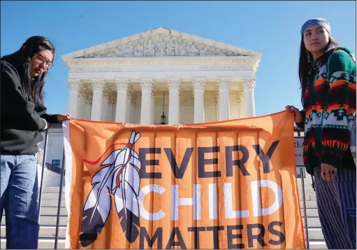  ?? (File Photo/AP/Mariam Zuhaib) ?? Demonstrat­ors stand Nov. 9 outside the U.S. Supreme Court as the court hears arguments over the Indian Child Welfare Act in Washington.