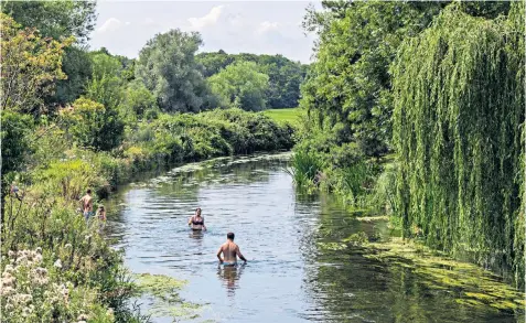  ??  ?? A couple swim in the River Stour, near Fordwich, Kent. Although temperatur­es in England were lower than in Europe, forecaster­s say the rest of August could bring more 30C heat