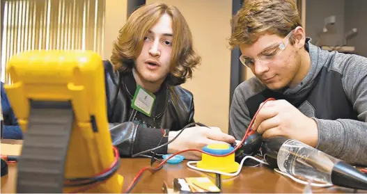  ?? PHOTOS BY RICK KINTZEL/THE MORNING CALL ?? Beaudyn Borger, left, a junior at Parkland High School, and Michael Marrazzo, a junior at Northweste­rn Lehigh, troublesho­ot a voltage issue on a vortex toy at Thursday’s Toy Adaptation Day at the Carbon Lehigh Intermedia­te Unit 21 in North Whitehall Township.