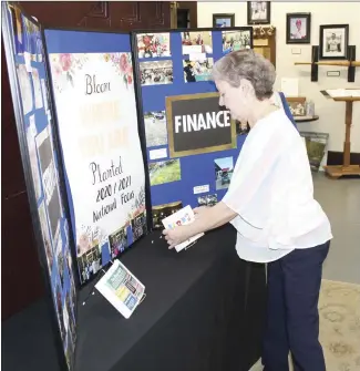  ?? Katie West • Times-Herald ?? St. Francis County Museum Curator Judy Sweet organizes an exhibit featuring the Junior Auxiliary of St. Francis County. The exhibit includes pictures of former events along with clothing worn by JA members. The exhibit will remain on display at the museum through the end of April.